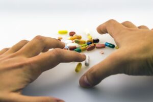 Person reaching for pills. (Drugs)