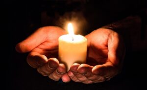 Religion and religious studies praying, hands holding candle