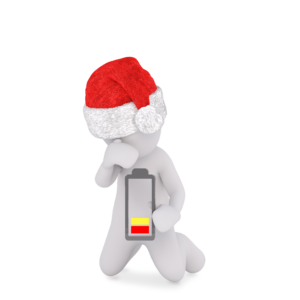 Anxiety figure wearing christmas hat holding depleting battery.